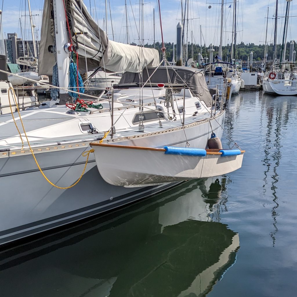 Spindrift 10 with hoisting rig alongside sailboat ready for bring aboard